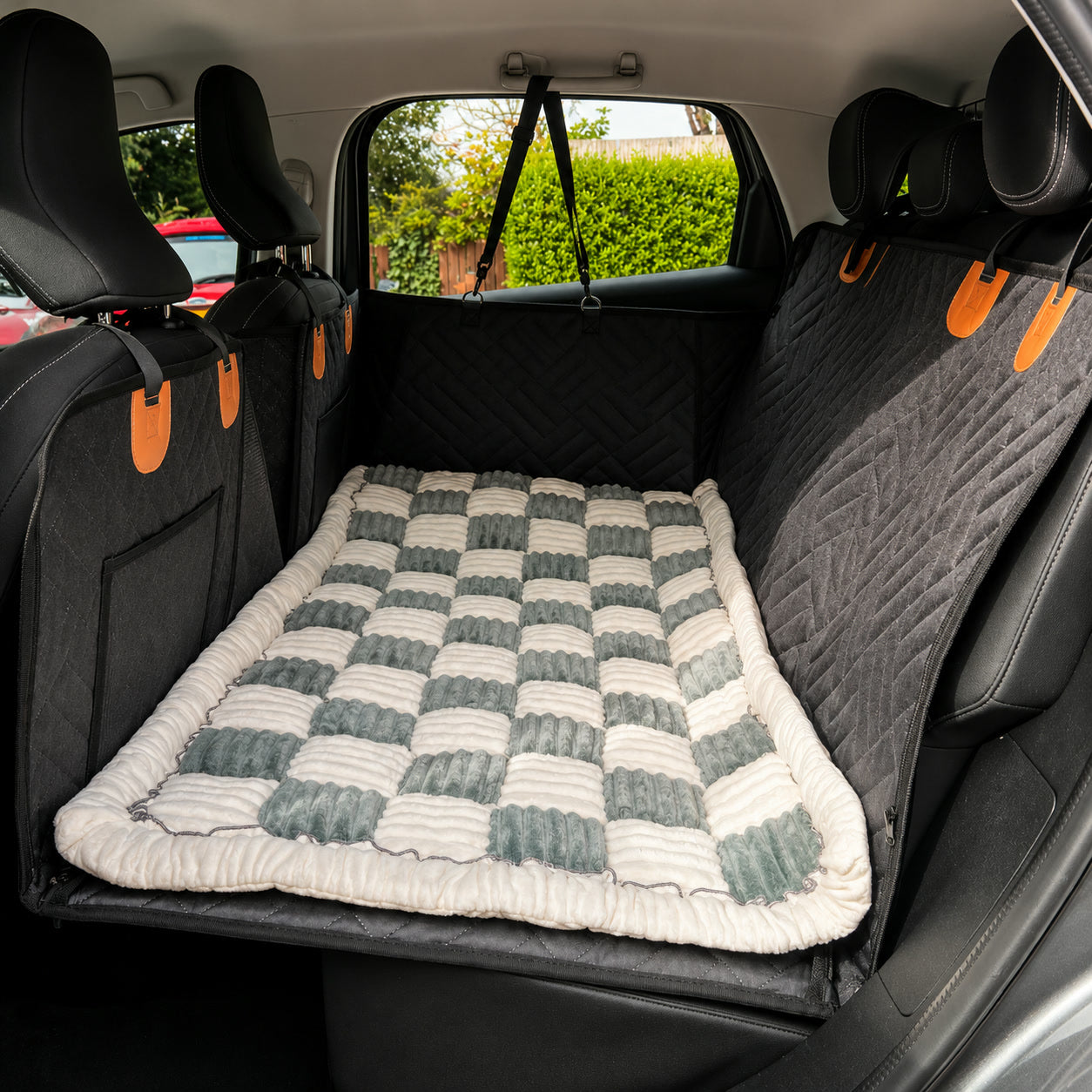 Gray checkerboard Luxe Dog Bed on a car back seat
