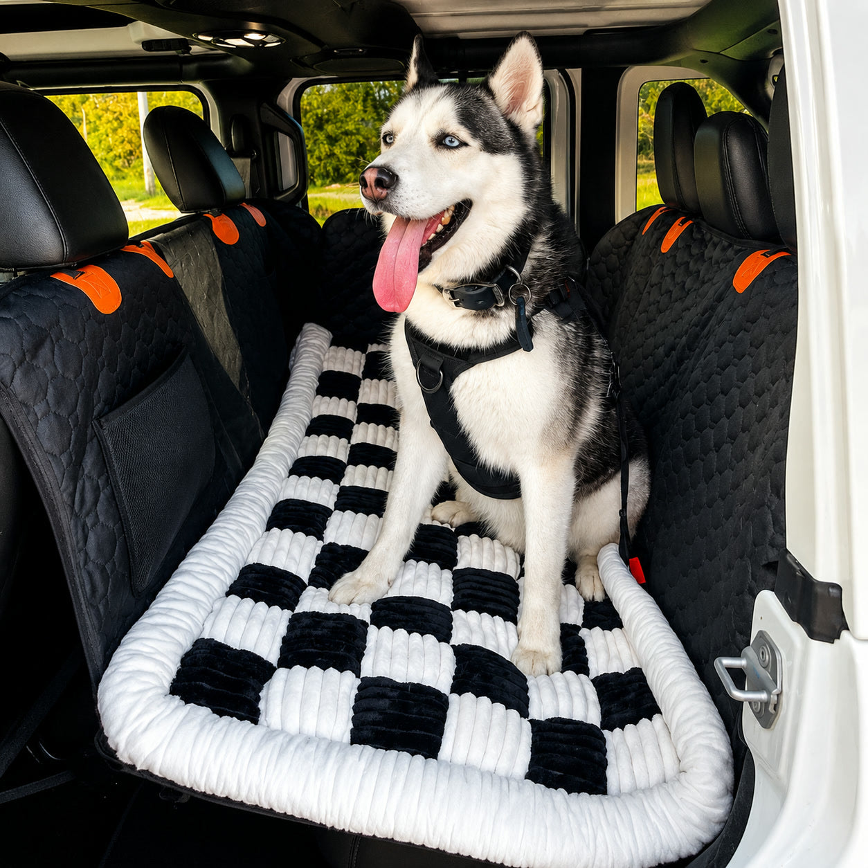 Husky sitting on the Luxe Dog Bed in the back of a car